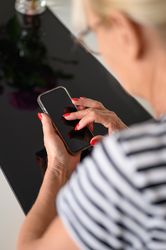 Crop woman using smartphone at home