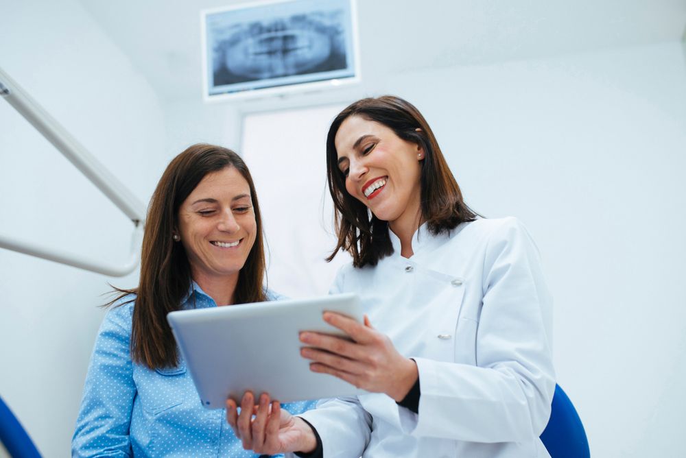 Dentist speaking with client showing document with information