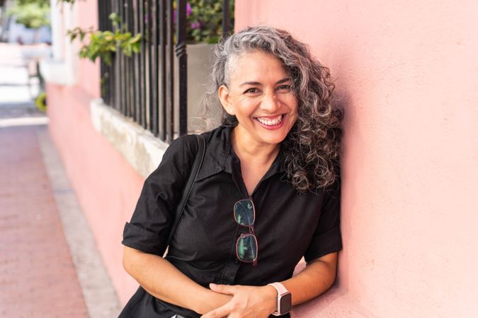 Confident gray haired mature woman laughing while looking at camera