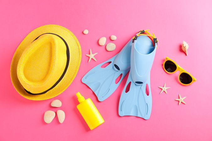 Sea vacation accessories on yellow background, top view