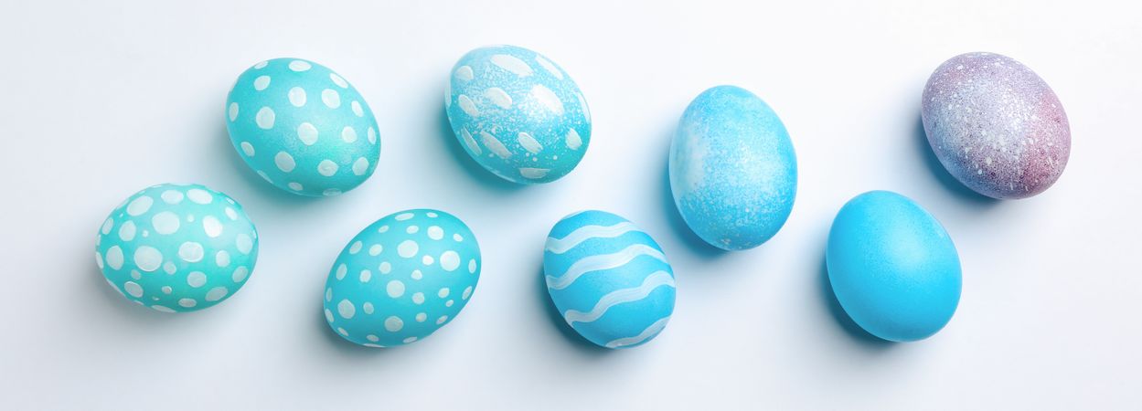 Flat lay composition with Easter eggs on plain background, space for text