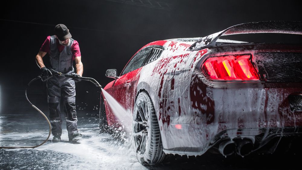 Close Up of a Red Performance Car Getting Care and Treatment at a Professional Vehicle Detailing Shop