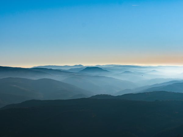 Snow and blue sky. Panoramic view of the silhouettes of the mountains.