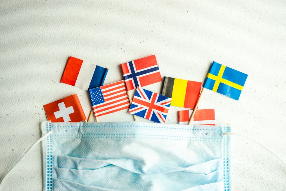 COVID-19 concept  with face mask and mini flags of countries