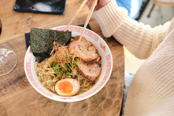 Faceless person eating delicious asian noodles