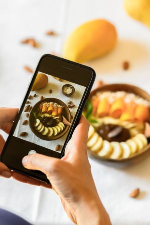 Crop blogger taking photo of healthy snacks