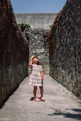 Girl in narrow stone walkway looking up