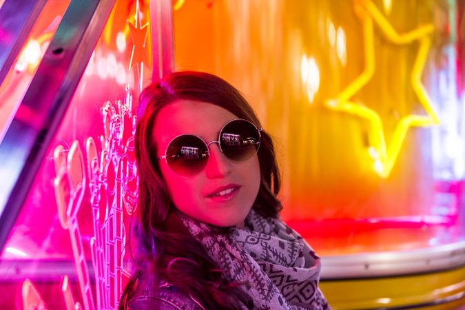 Stylish young woman near illuminated board