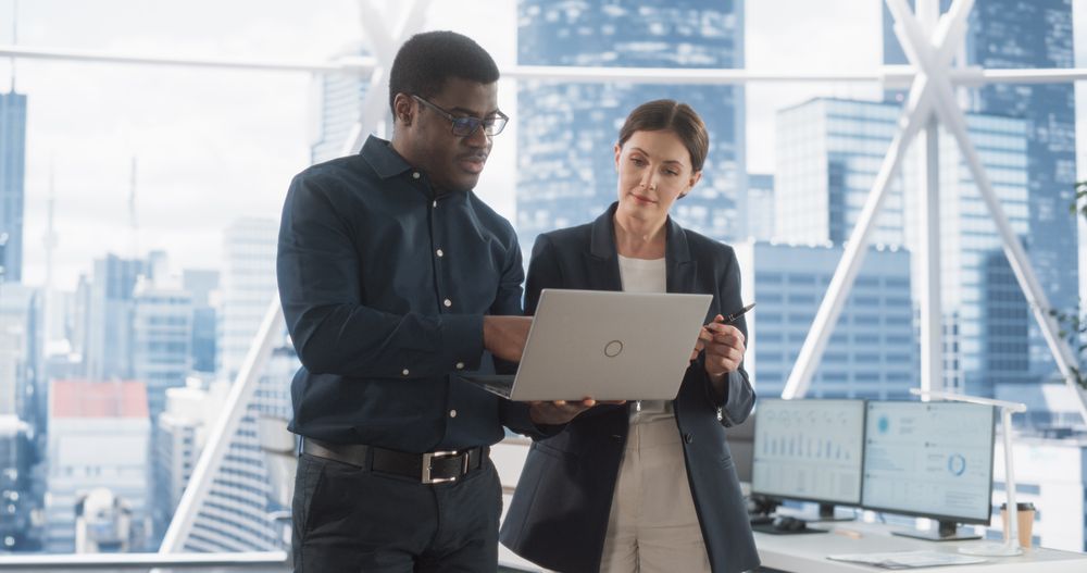 Businesspeople in Modern Office: Business Meeting of Two Managers Using Laptop.