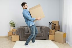 Moving concept, man with boxes in apartment.