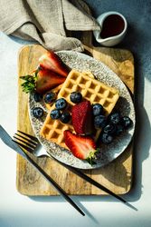 Looking down at waffle breakfast with blueberries & strawberries
