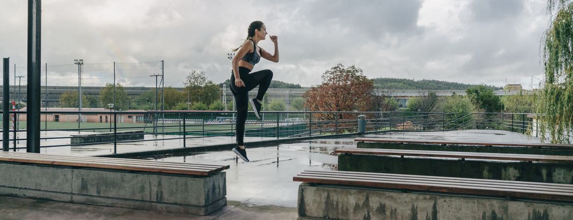 Woman jumping on benches doing training