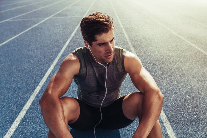 Track athlete relaxing on running track