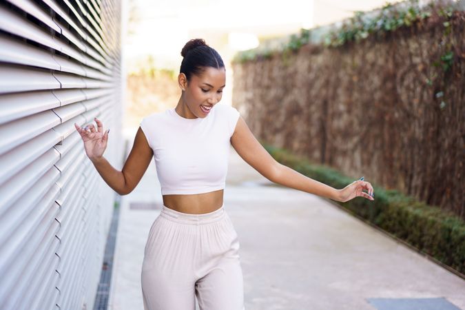 A Joyful, Young Woman Dancing Gracefully in a Vibrant Urban Setting Full of Life