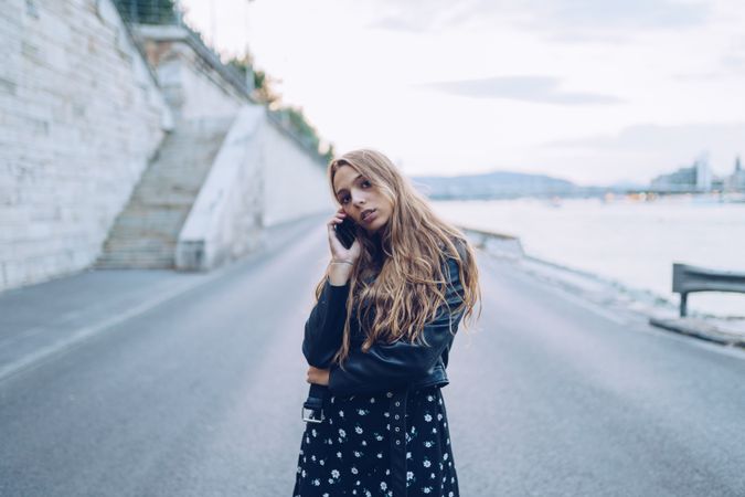 Long haired stylish woman speaking on smartphone