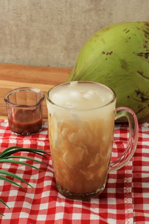 Side view of Indonesian coconut drink on red tablecloth