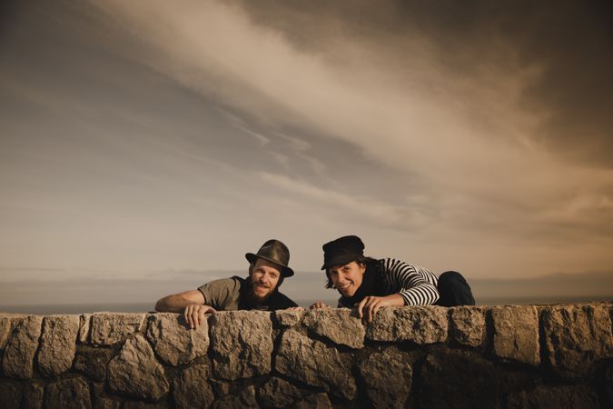 Man and woman leaning out from stones