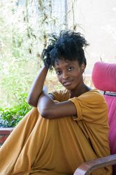 Beautiful woman with yellow t-shirt dress relaxed looking at camera