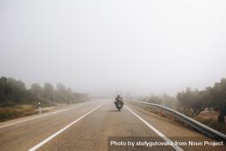 Motorcyclist riding into the fog bGmZx5