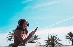 Woman listening to music at handrail