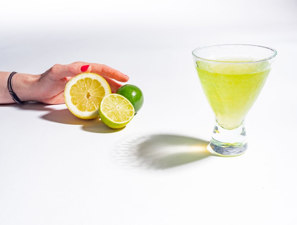 Cocktail glass with lemon juice and sliced citrus