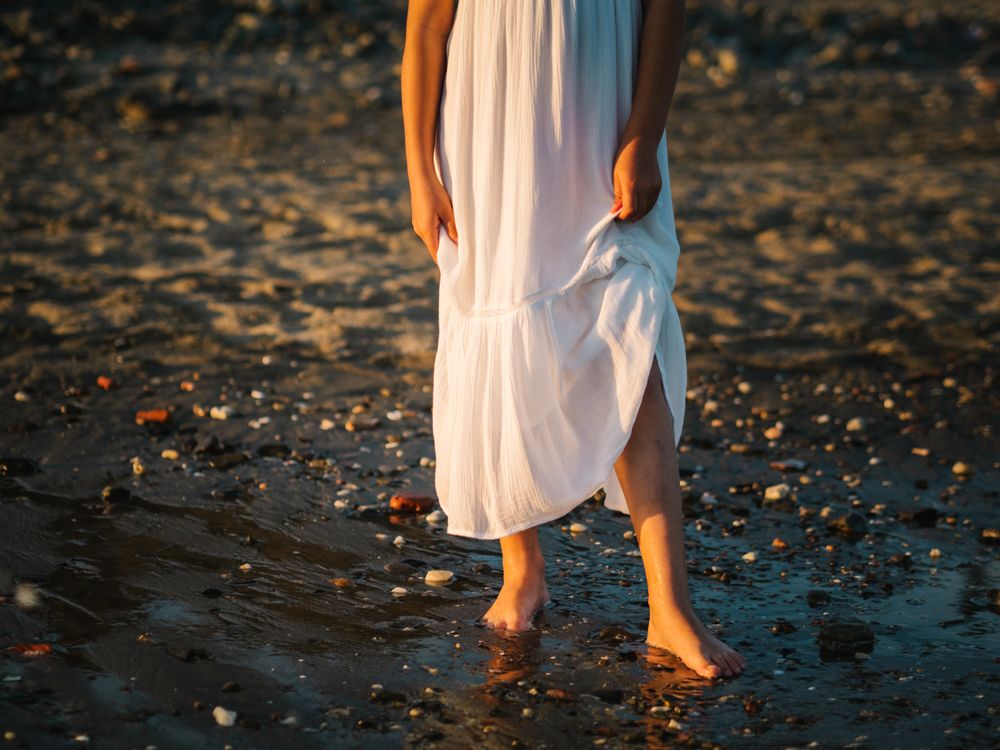 Adorable girl walking on seaside at sunset