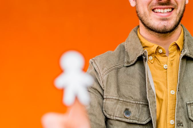 Smiling man holding funny paper toy