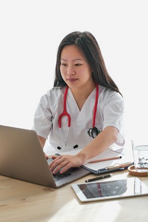 Asian physician browsing laptop in clinic