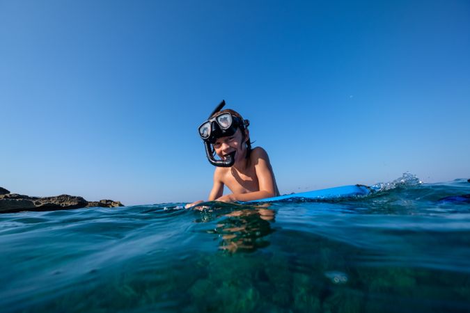 Preteen boy in snorkeling mask preparing for diving in sea