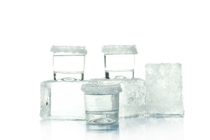 Salted shot glasses stacked with large ice cubes