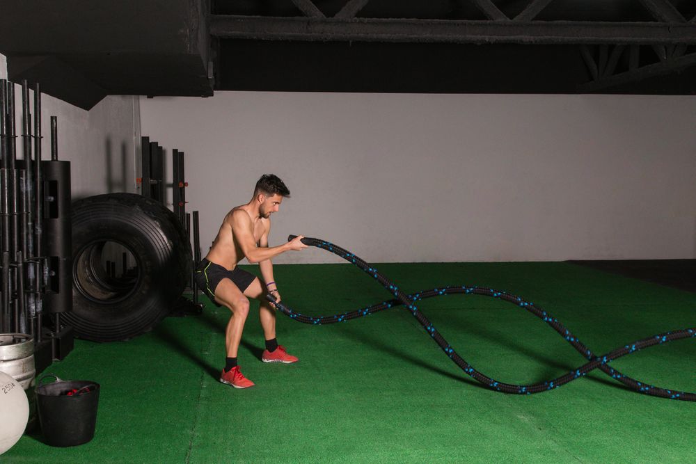 Man training with ropes in gym