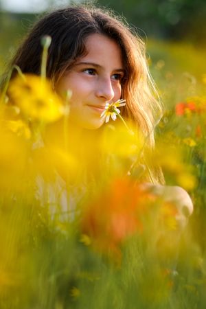 Girl smelling flower in meadow