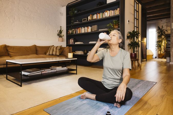 Grey haired Woman doing yoga at home