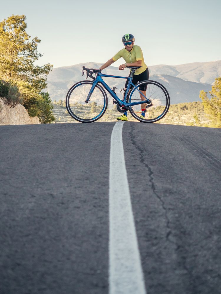 man resting while riding a bicycle on a mountain road