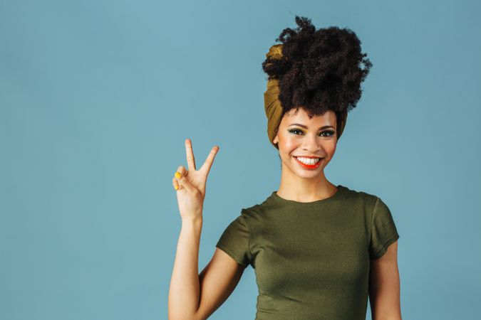 Studio shoot of Black woman smiling making the peace sign