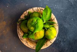 Top view of fresh green tangerines in bowl