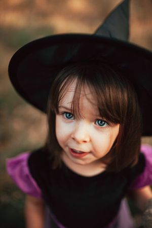 Girl in a witch hat looking up