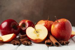 Apples on a wooden table with anise and cinnamon sticks