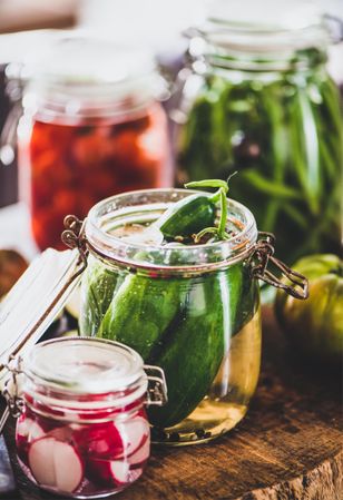 Glass jars of pickled vegetables on kitchen counter