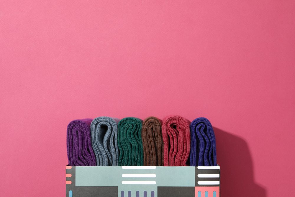 Multicolored high socks on a pink background.