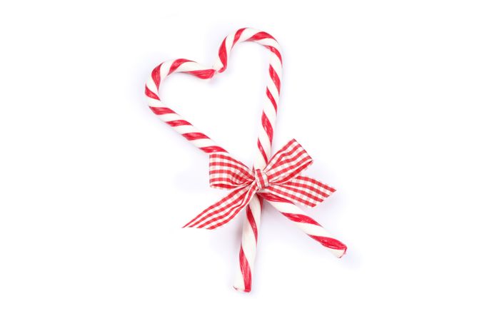 Sweet candy canes with bow isolated on blank background