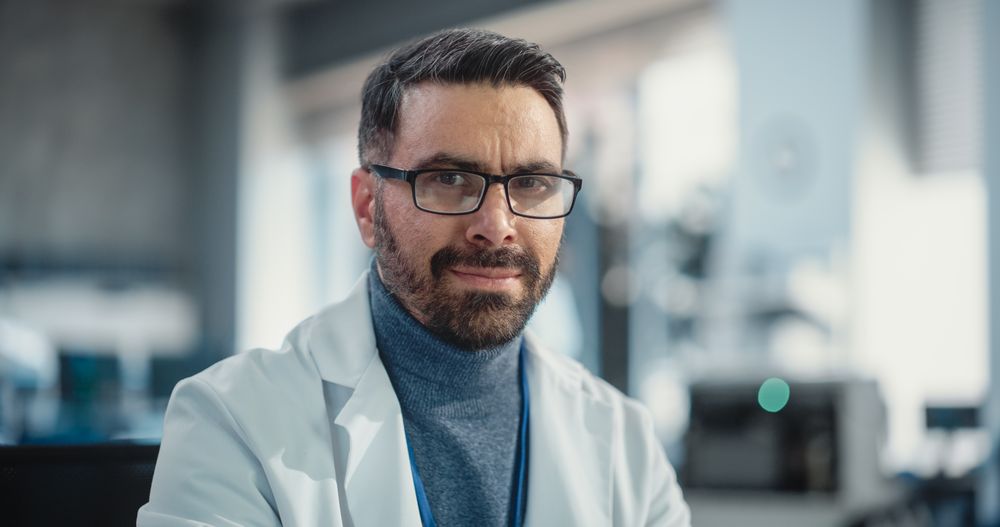 Portrait of Man Wearing Glasses and a Lab Coat Looking at the Camera.