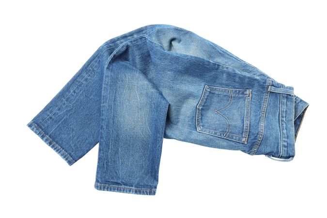 Close-up of folded jeans, isolated on light background