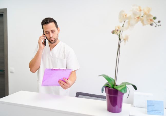 a physiotherapist attending to his patients by telephone