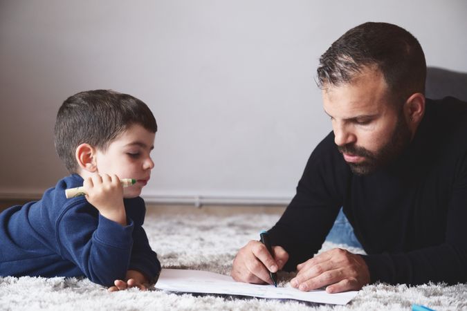 Father and son drawing on floor