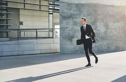 Man in business attire holding skateboarding
