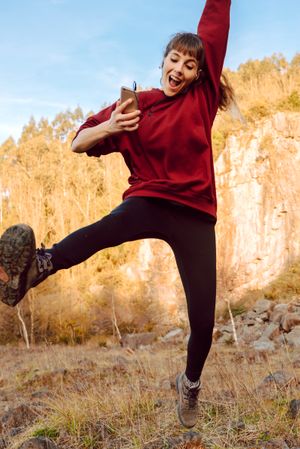 Young woman with smartphone dancing