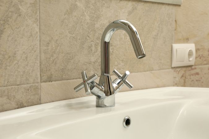 Sink and faucet in modern bathroom, close up