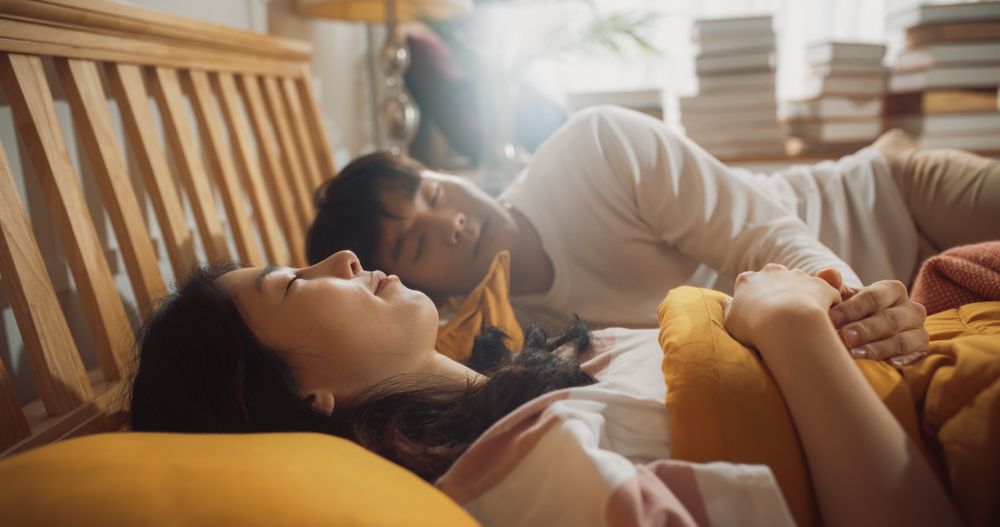 Young Korean Couple Sleeping in Bed, Caring Husband Waking up His Wife, Getting Ready for New Day.