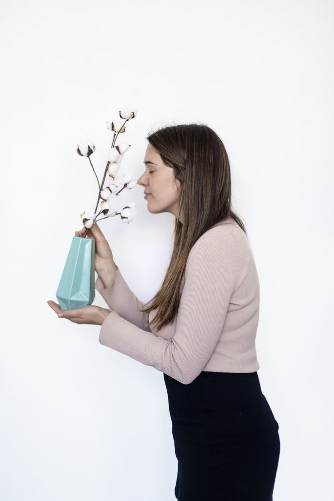 Portrait of a pretty woman smelling a plant